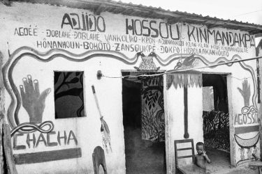 O convento do Dagoun, próximo à Singbomey, é uma pequena concessão que abriga o templo e a casa do chefe do culto. O nome do vodu está pintado no muro e na entrada, ao lado de uma representação do “Aïdôhoêdo”, o arco-íris sagrado sob a forma de duas serpentes, marca dos cultos Dan. - 29 de janeiro de 1996 - Uidá, Benim