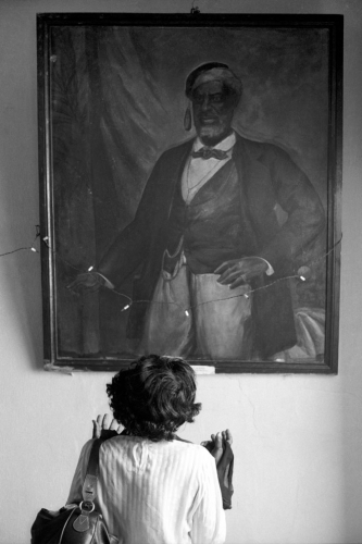 Na cerimônia privada de entronização, descendente de Francisco “Chicou” de Souza, o Chachá III, reza diante do retrato de seu ancestral, em Singbomey. - 7 de outubro de 1995 - Uidá, Benim